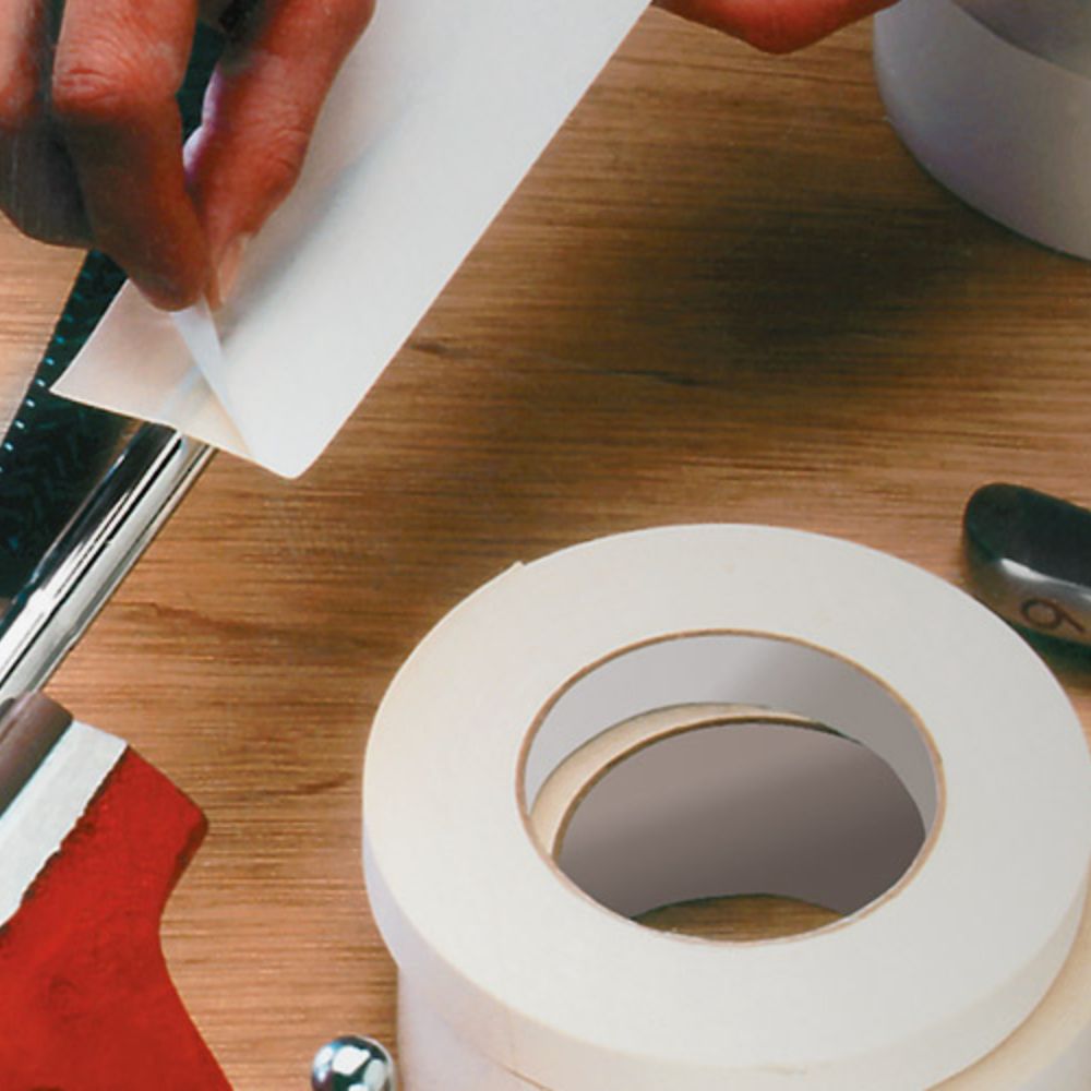 Professional application of 591 double-coated flatback paper tape to a metal surface for industrial mounting