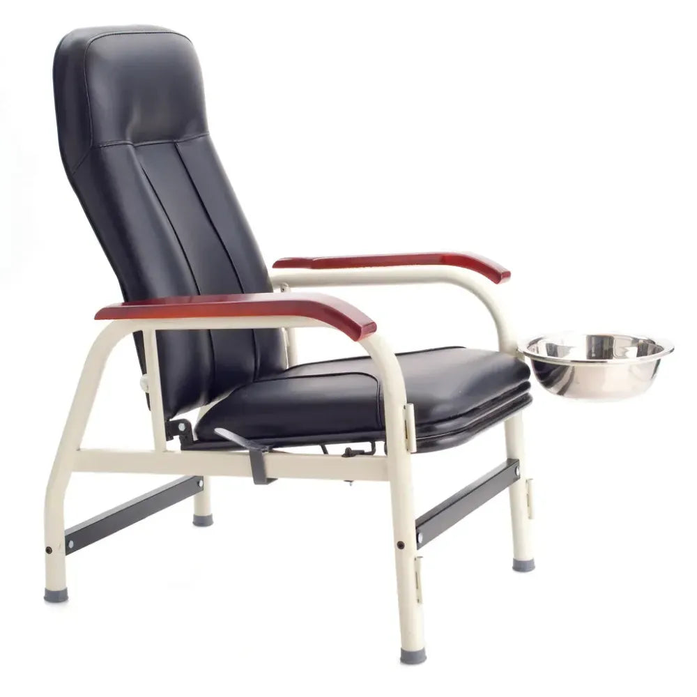 Black Treatment FSTCHAIR Chair featuring a padded high-back design, ergonomic armrests with wood-grain trim, and an integrated stainless steel wash basin on a swivel mount.