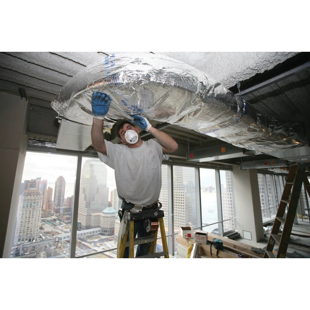 Worker installing CertainTeed SoftTouch Duct Wrap insulation on HVAC ductwork in a commercial building
