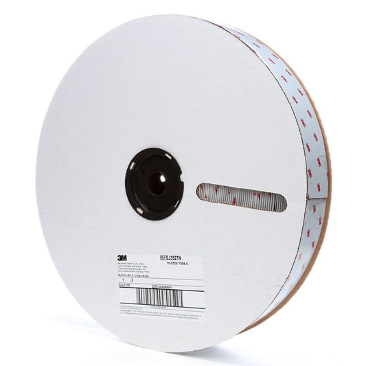 A large bulk manufacturing roll of black 3M SJ3526N reclosable fastener nylon hook tape with white protective cardboard flanges and product identification labels isolated on a white background