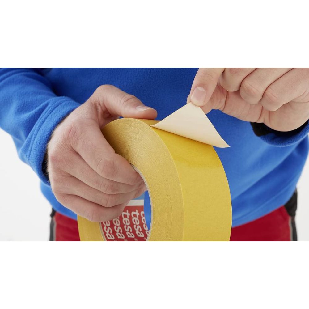 Removing the protective paper liner from 4970 double-coated PVC tape for immediate surface bonding