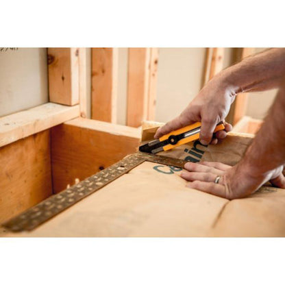 Warehouse worker using OLFA SK-16 safety cutter to slice plastic stretch wrap on a pallet