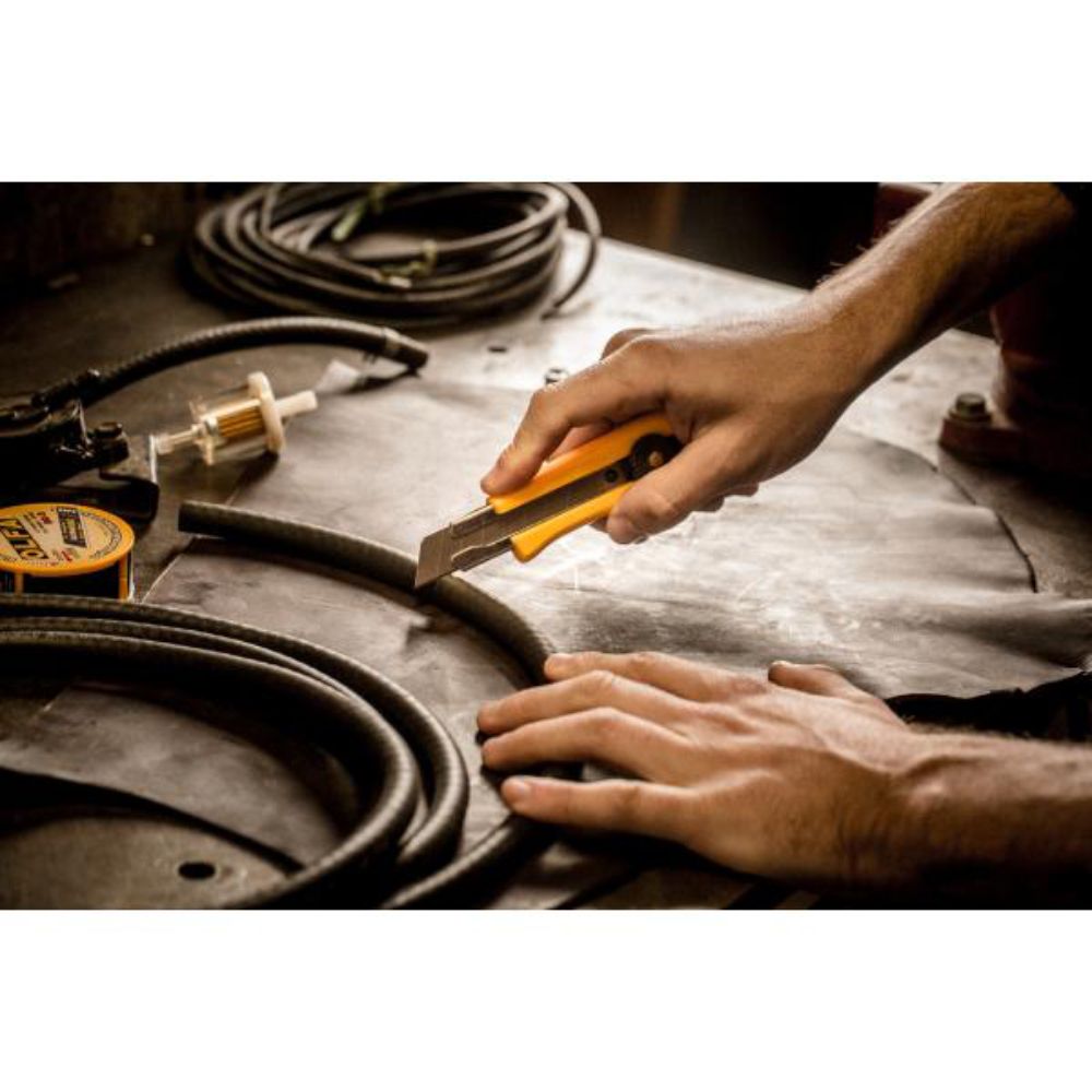 Hand slicing cleanly through thick corrugated cardboard using an OLFA CL utility knife