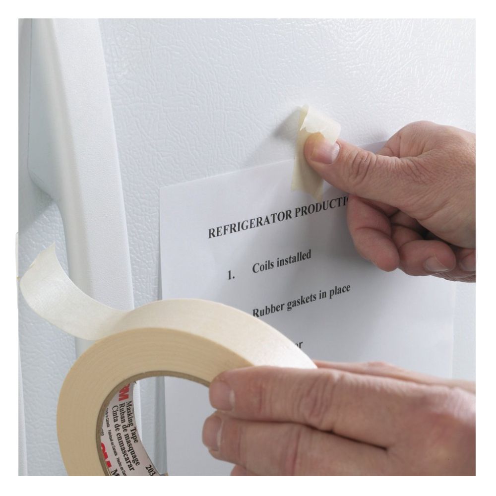 Hands using 3M 203 beige masking tape to secure a production document to a white refrigerator surface.