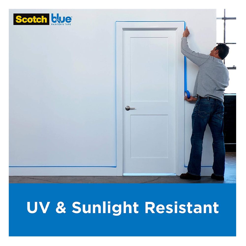 A man applying blue ScotchBlue painter's tape around a white door frame, highlighting its UV and sunlight resistance.