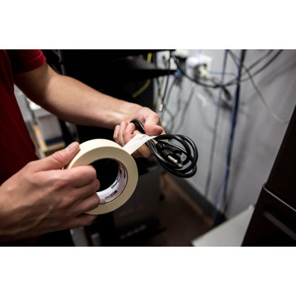 Person applying Shurtape CP105 beige masking tape to black power cords