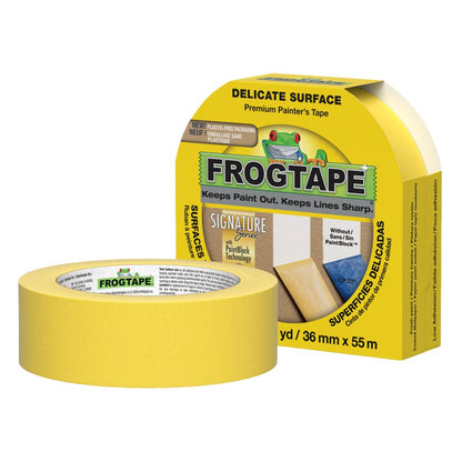 A hand peeling away yellow FrogTape to reveal a clean, sharp paint line between grey and white sections of a wall.