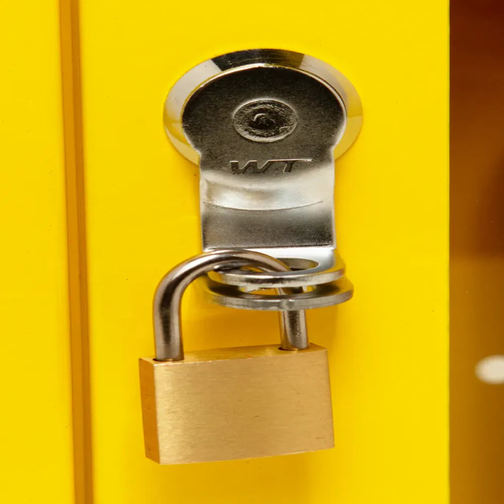 Metal lock and key on yellow emergency alarm cabinet