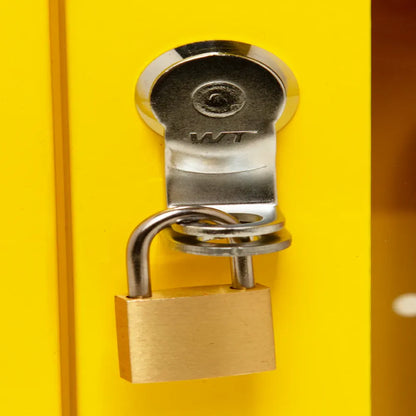Metal lock and key on yellow emergency alarm cabinet