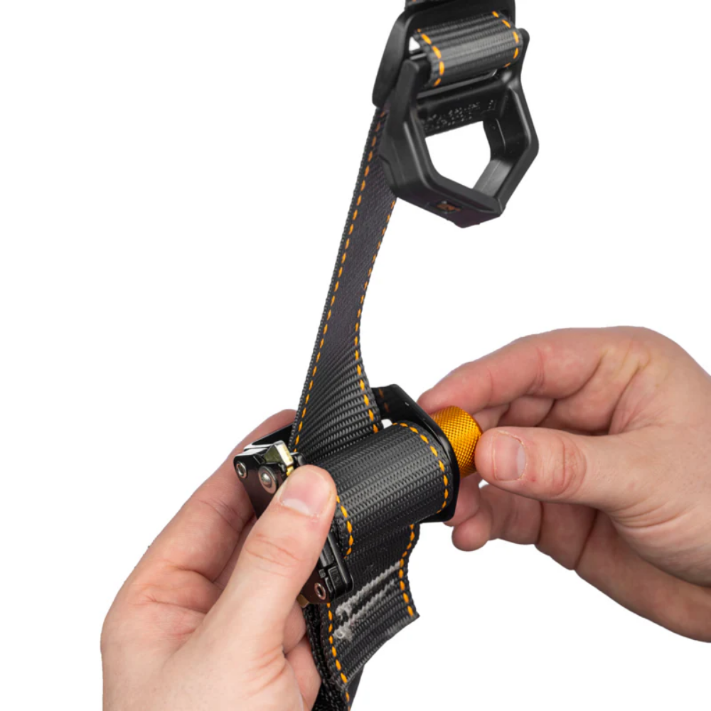 Close-up view of the zinc-plated steel pass-through mating chest buckle on the LEO safety harness, engineered for quick adjustment.