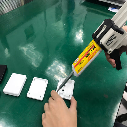 Applying Henkel Loctite EA E-90FL Hysol flexible grey epoxy adhesive to a plastic housing using a dual cartridge applicator gun.