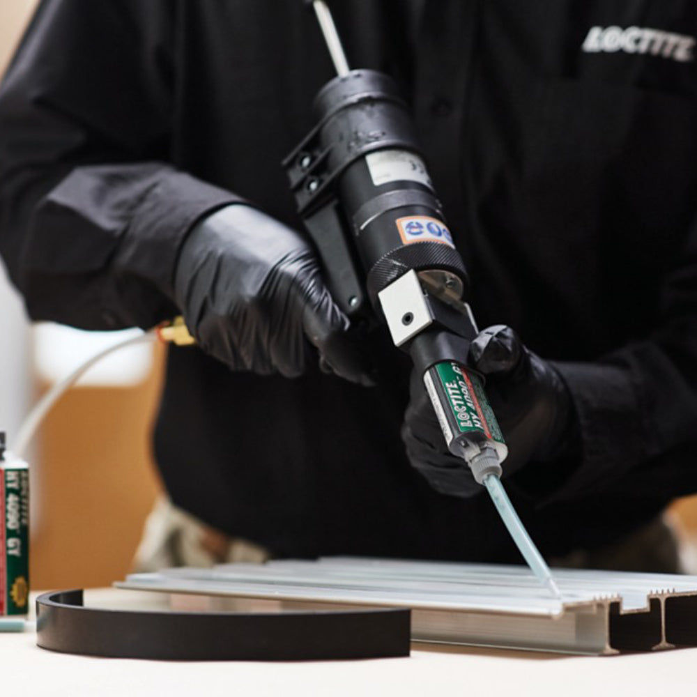 Applying Henkel Loctite HY 4090 GY structural instant hybrid adhesive to an aluminum profile using a pneumatic dual cartridge dispenser gun.