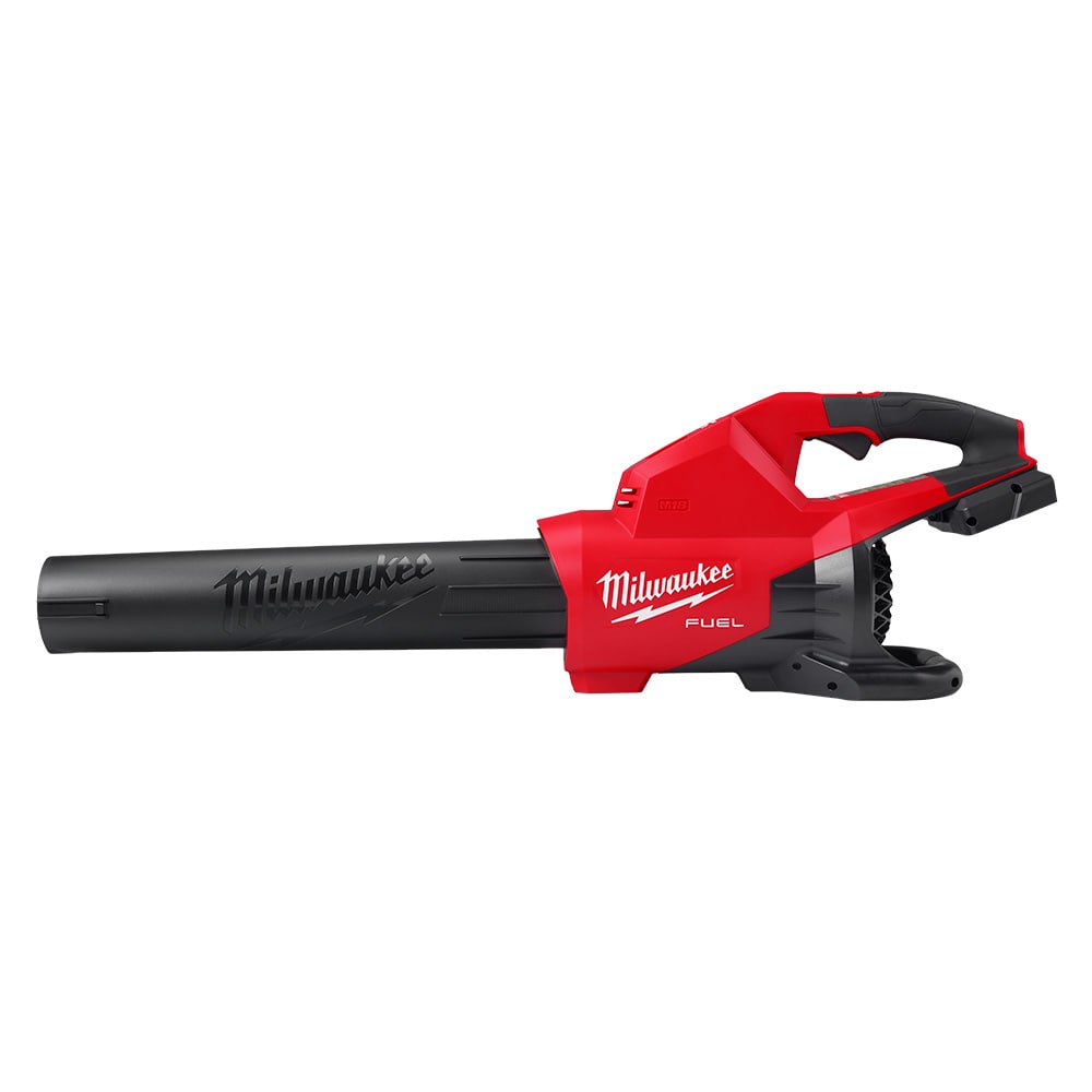 Close-up of a worker using a Milwaukee cordless handheld blower to blast debris and grass clippings off a concrete garden walkway.