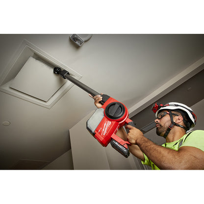 Worker using Milwaukee M18 FUEL cordless compact vacuum with extension wand to clean ceiling vent on job site