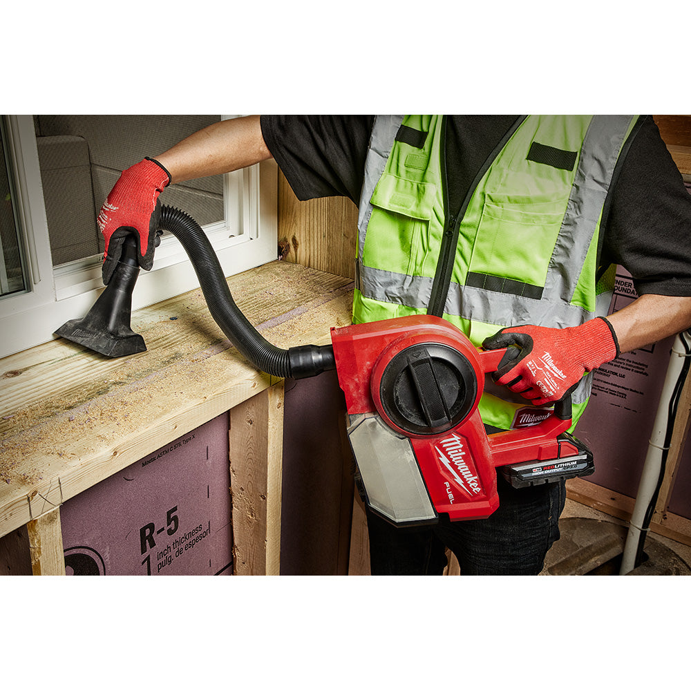 Milwaukee M18 FUEL compact vacuum with flexible hose attachment cleaning window frame on job site