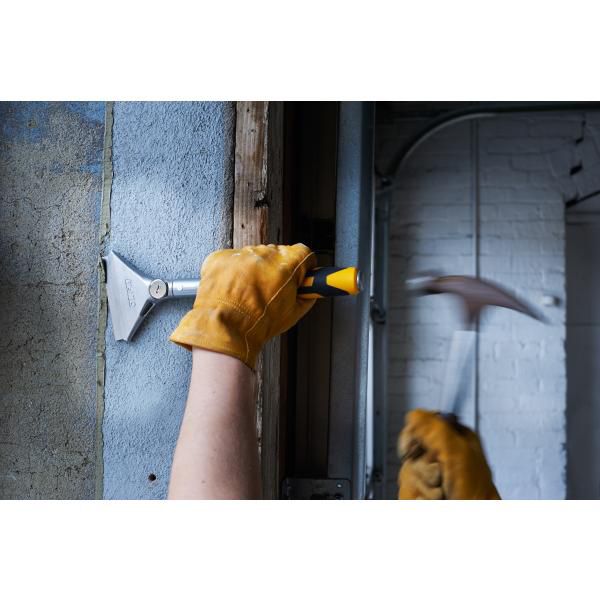 Worker using Olfa heavy duty scraper with yellow handle to scrape wall surface wearing leather gloves