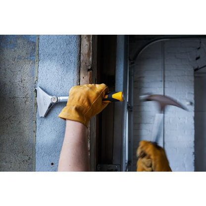 Worker using Olfa heavy duty scraper with yellow handle to scrape wall surface wearing leather gloves