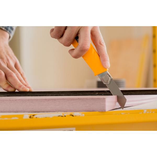 Precision cutting of a pink rigid foam insulation board using an OLFA L-1 heavy duty snap off utility knife guided by a straight edge
