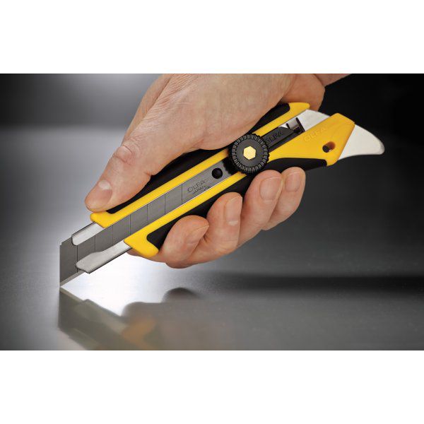 Close up of a hand securely holding an OLFA L-5 fiberglass reinforced utility knife over a metallic surface