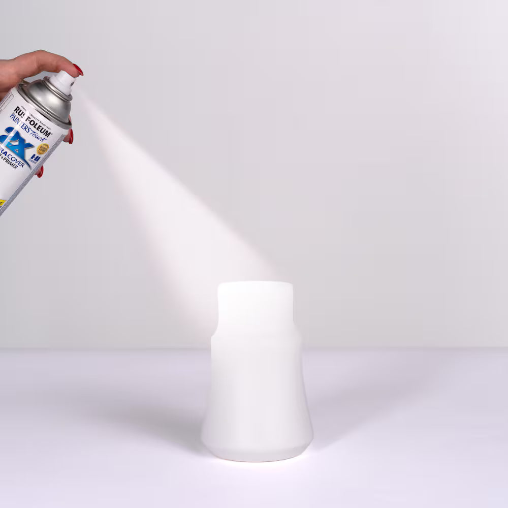 Applying Rust-Oleum Painter's Touch 2X Ultra Cover White Primer spray paint on a decorative vase.