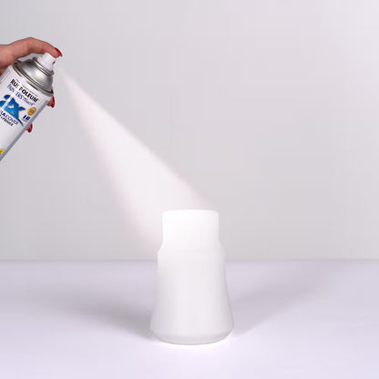 Applying Rust-Oleum Painter's Touch 2X Ultra Cover White Primer spray paint on a decorative vase.