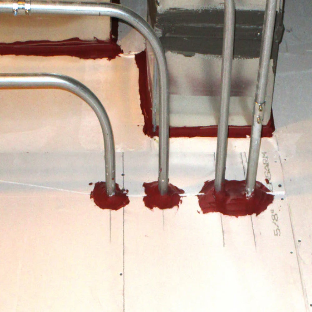 STI LC120 Specseal endothermic firestop sealant applied around pipe penetrations through fire-rated floor and wall assembly