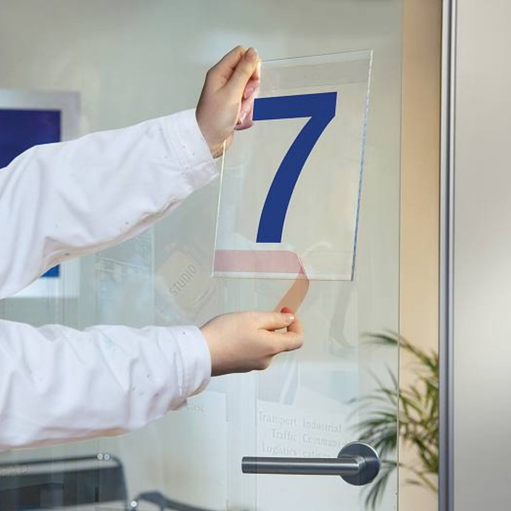 Applying Clear Double-Sided Tape on Glass Door with Number Sign