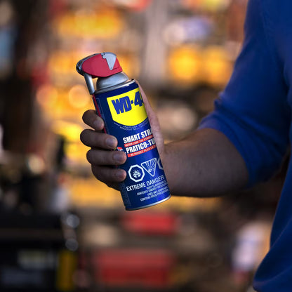 Close-up of a person holding a 325g can of WD-40 Multi-Use Product with the Smart Straw in the down position for wide spray.