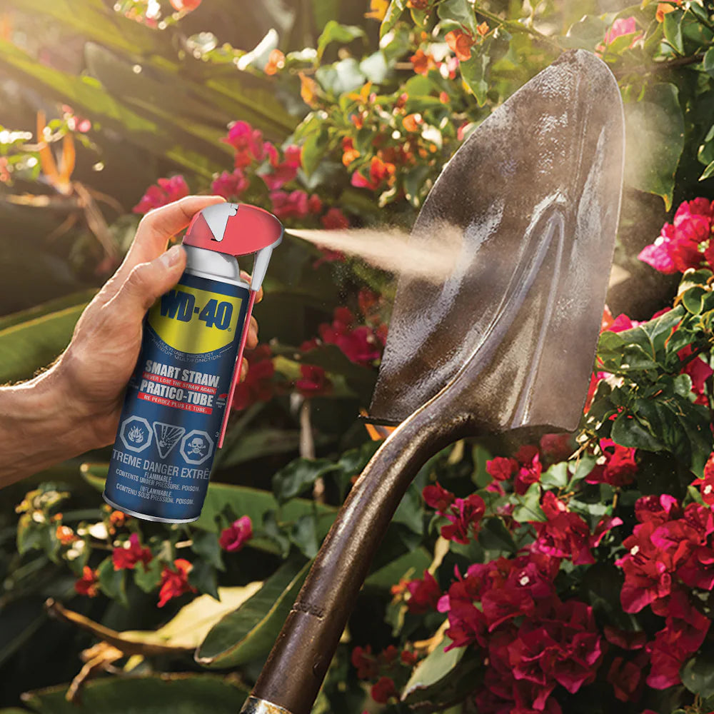WD-40 Multi-Use Product being sprayed on a metal digging shovel to prevent rust and corrosion.
