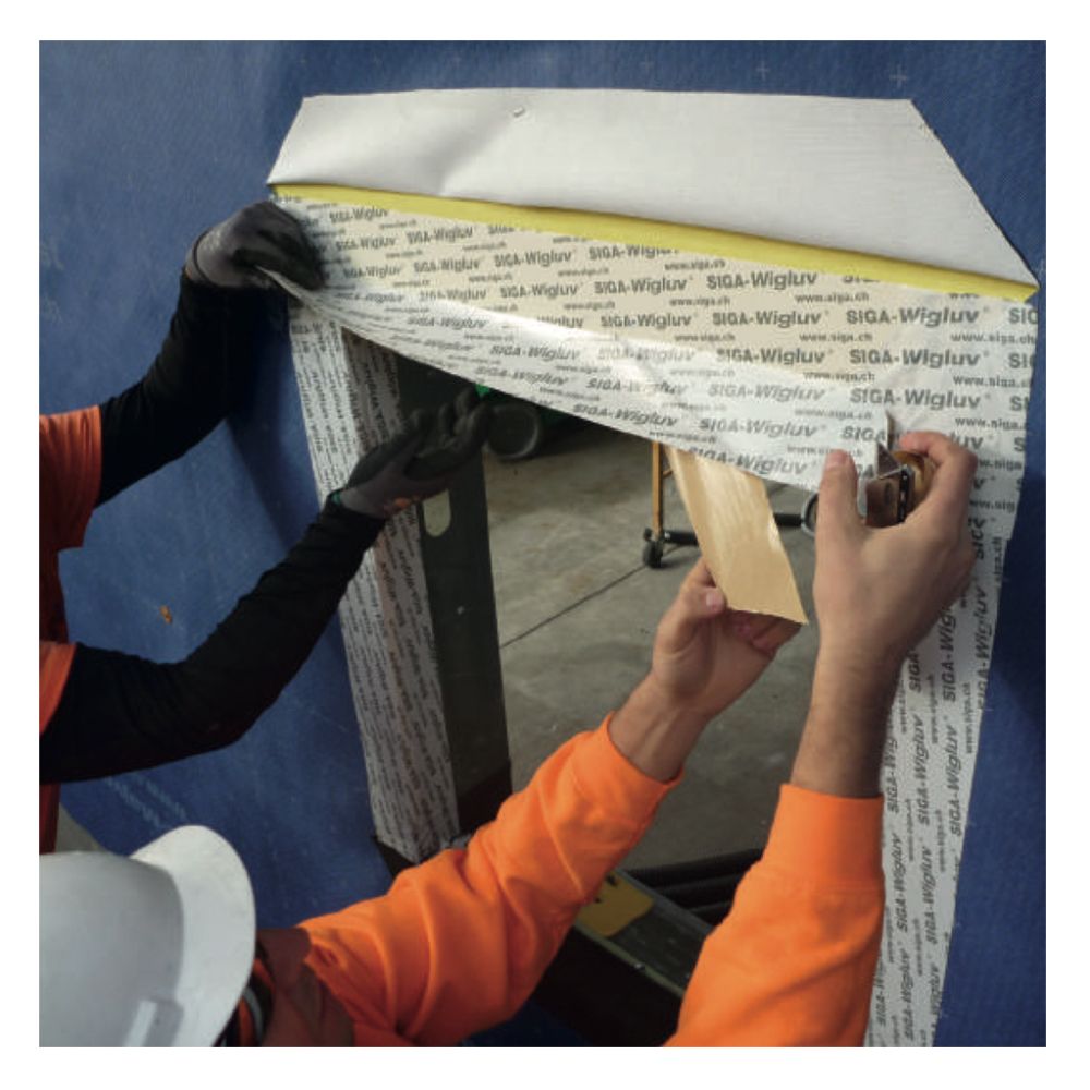 Detailed application of extra-wide Wigluv 150 window flashing tape around a rough opening to provide an airtight and rainproof exterior seal.