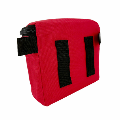 Angled front view of the compact red fabric personal first aid pouch with its clear compliance label pocket and reflective trim.
