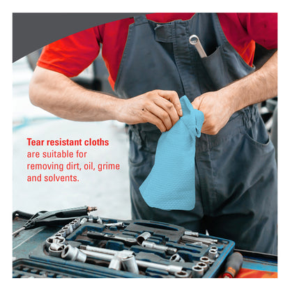 A mechanic in grey overalls uses a blue tear-resistant WypAll X70 cloth to clean his hands next to a professional tool set in a workshop