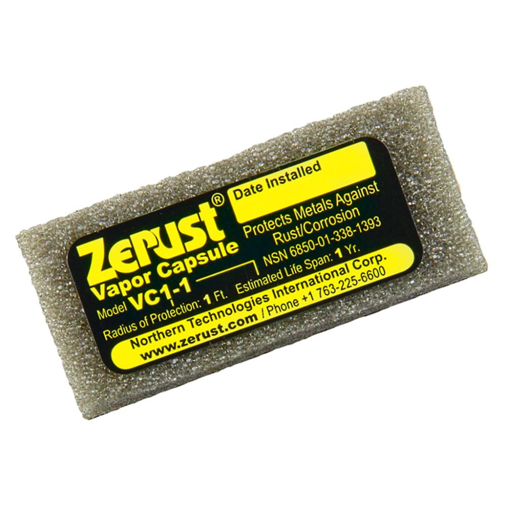 A close-up of a small grey foam Zerust VC1-1 VCI vapor capsule with a black and yellow product label detailing its 1 foot protection radius