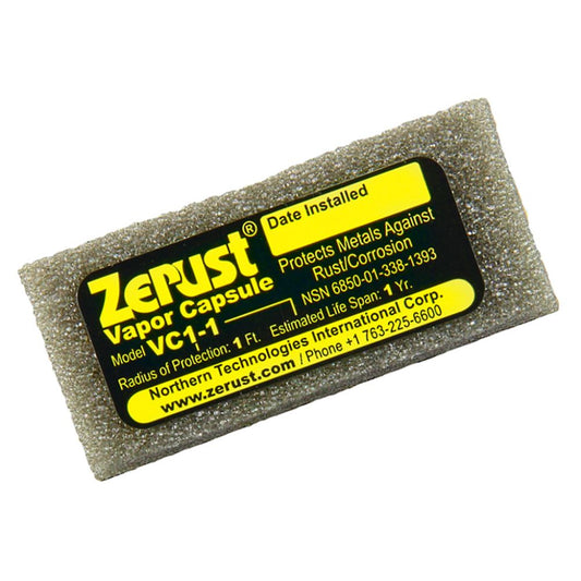 A close-up of a small grey foam Zerust VC1-1 VCI vapor capsule with a black and yellow product label detailing its 1 foot protection radius
